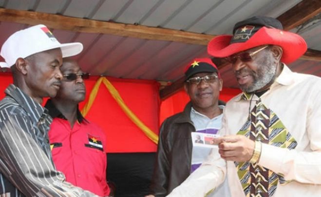 Primeiro secretario do mpla no Huambo, Kundi Paihama, entrega a cartão a novo militante